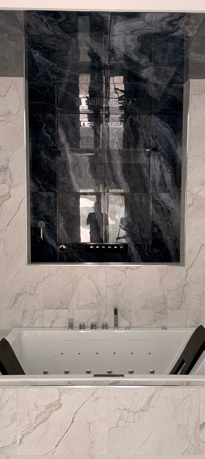 Dark marble walk-in shower with rainfall head, body sprays, and a handheld shower